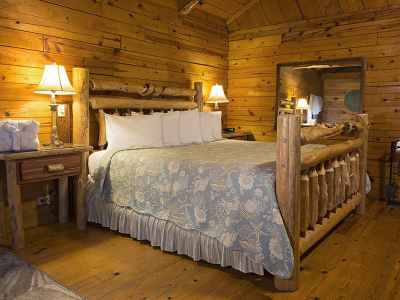 The cabin's king-size bed offers nearby fireplace and soaking tub ambience.