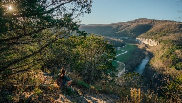 A hiker takes in the view of the Buffalo River from the Steel Creek Overlook.
