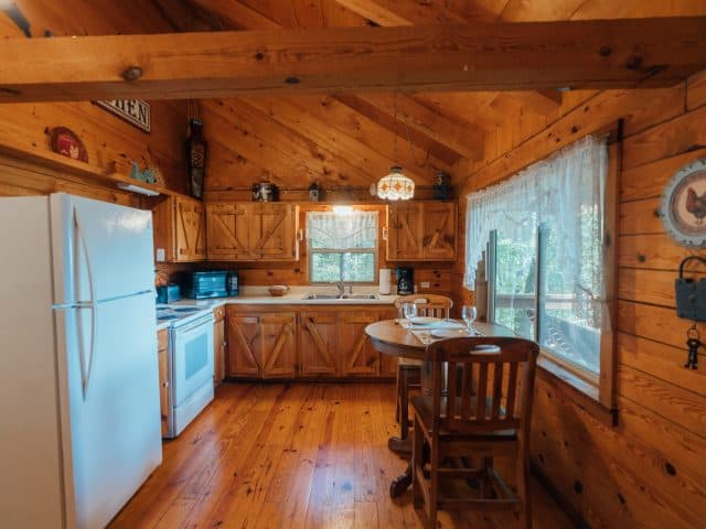 The fully-furnished kitchen of the Mountain Sunrise Cabin offers a romantic dining spot for two.