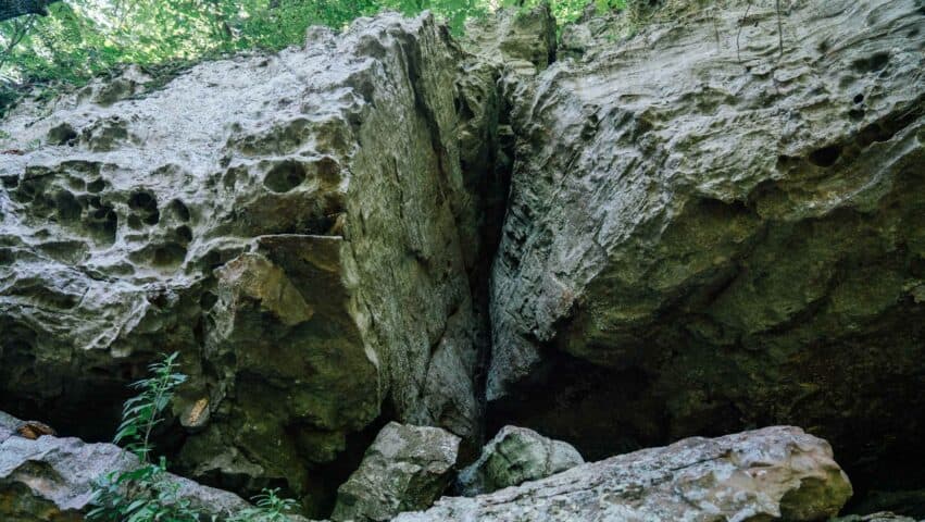 A view of the rock bluffs above hikers on the Round Top Mountain Trail.