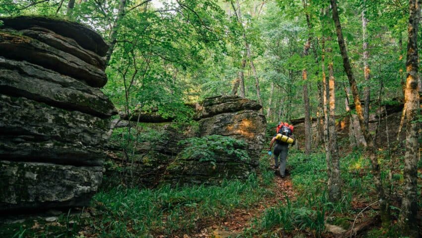 A Backpacker hiking through rock formations on the BRT.