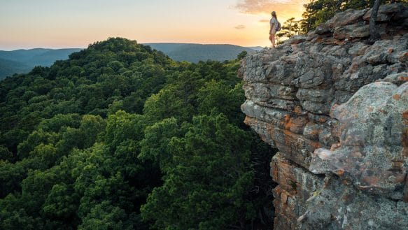 A hiker taking in sunset at Sam's Throne.
