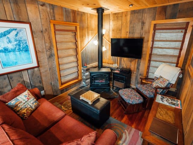The Creekside Cabin features a cozy living area with with an electric fireplace.