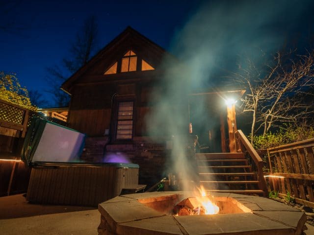 The patio of the Creekside Cabin with fire pit, hot tub, and Grill.