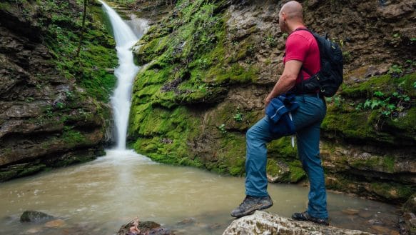 A hiker stands in front of Elise Falls in the Smith Creek Nature Preserve