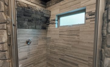 This cabin's beautiful, rustic bathroom features a gorgeous walk-in waterfall shower.