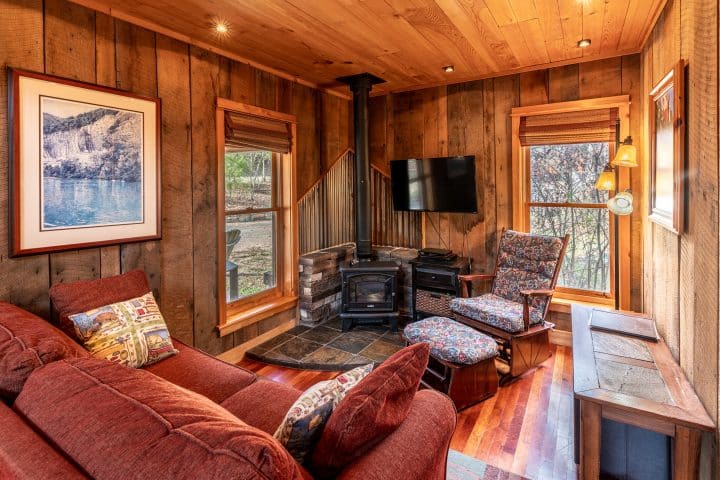 The Creekside Cabin features a cozy living area with with an electric fireplace.