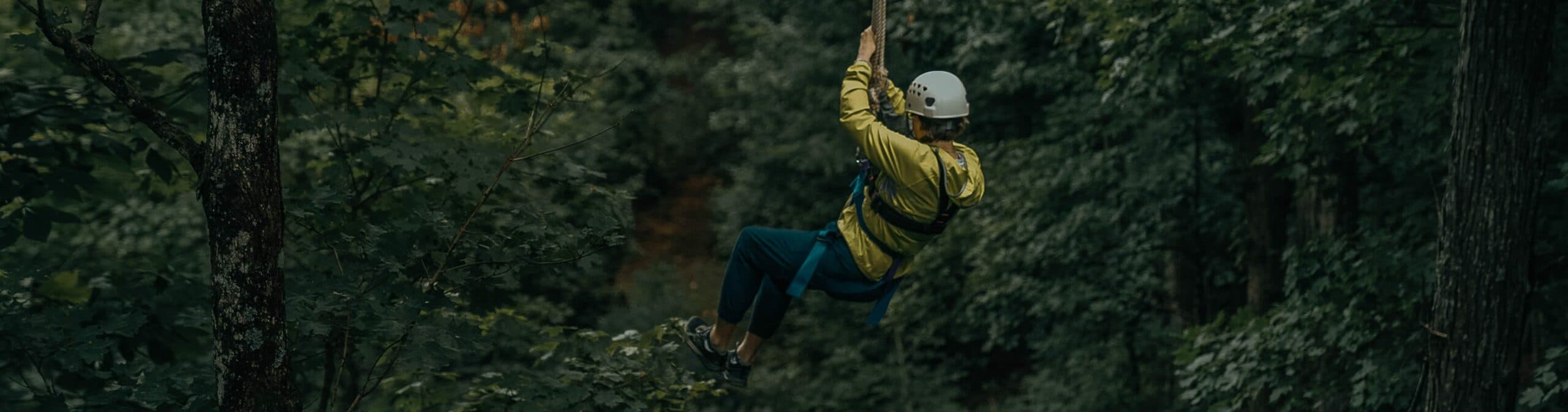 Woman zip lining through trees