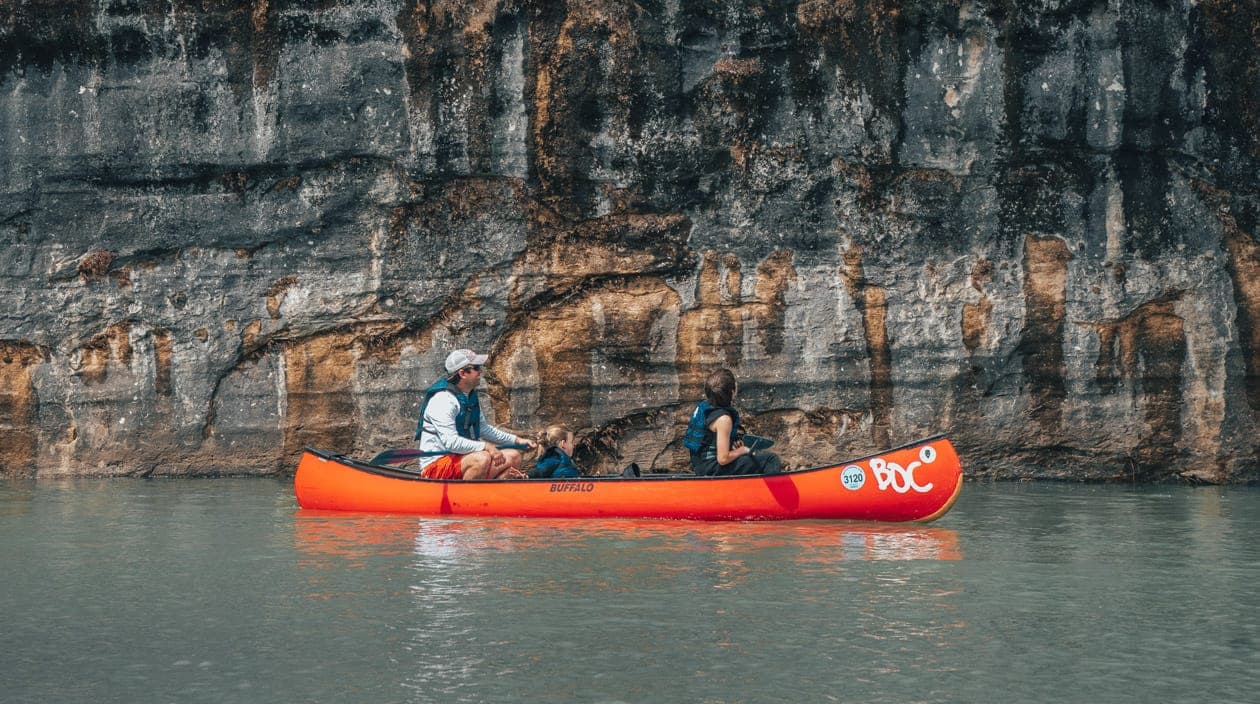 canoe by rock cliff