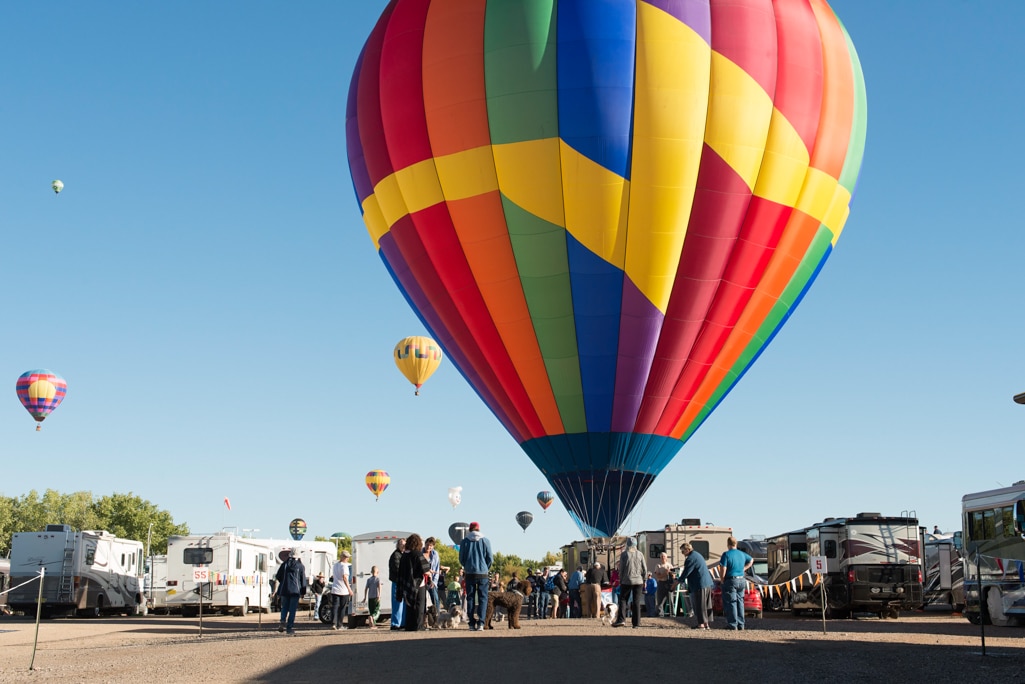 A hot air balloon lands in the South RV Lot near the Albuquerque Balloon Fiesta event field.